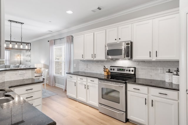 kitchen featuring hanging light fixtures, light hardwood / wood-style floors, tasteful backsplash, white cabinets, and stainless steel appliances