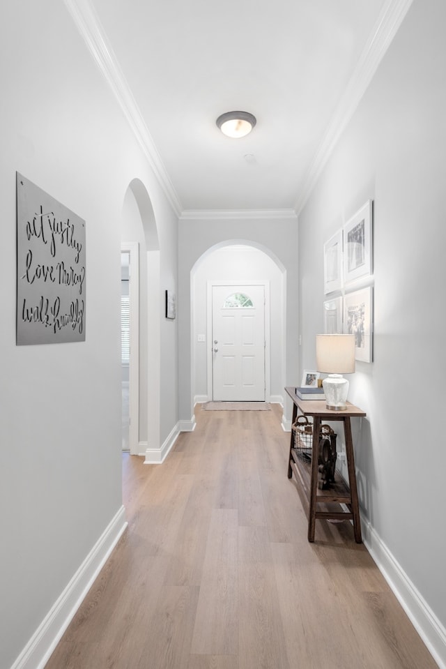 hall with ornamental molding and light hardwood / wood-style flooring