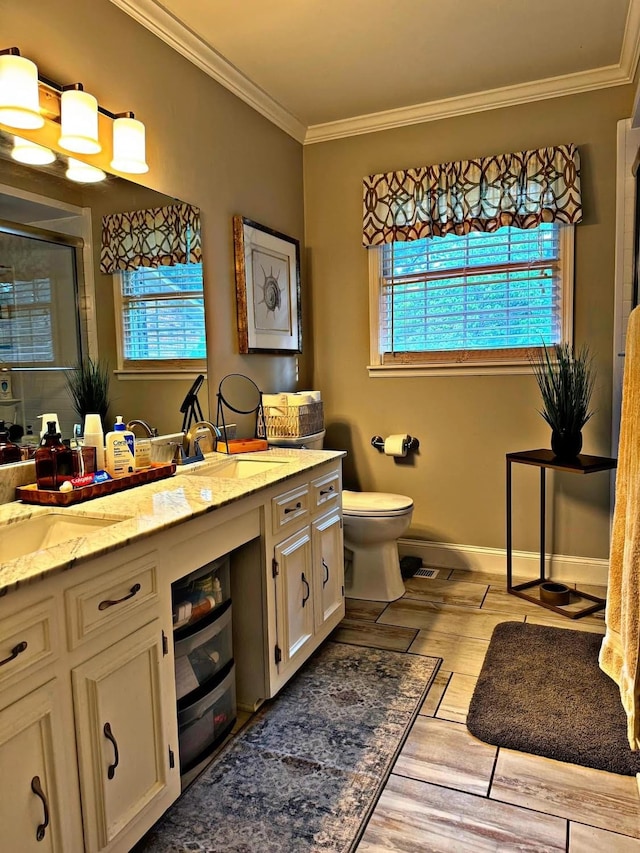 bathroom featuring wood-type flooring, ornamental molding, vanity, and toilet