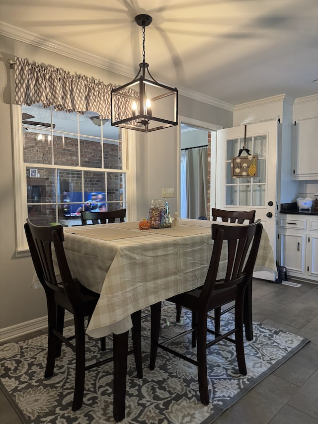 dining space with dark wood-type flooring, crown molding, and a chandelier