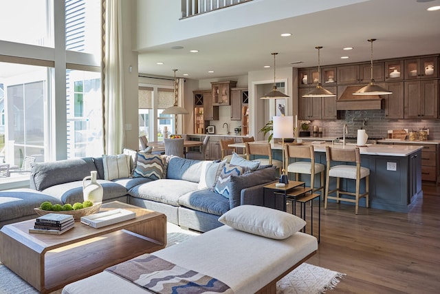 living room with a high ceiling, dark hardwood / wood-style floors, and sink