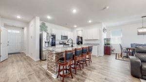 kitchen featuring an island with sink, white cabinetry, appliances with stainless steel finishes, a breakfast bar area, and light hardwood / wood-style floors