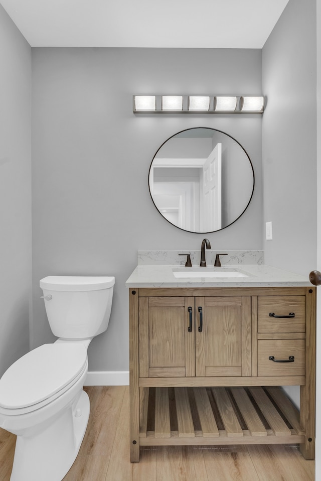 bathroom featuring wood-type flooring, vanity, and toilet