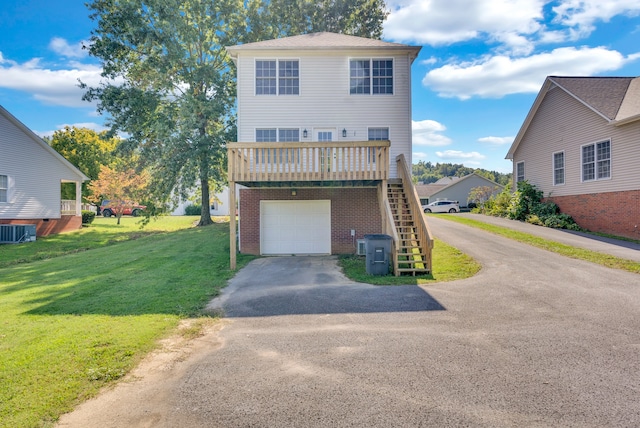 view of front of house featuring a garage, central AC unit, and a front yard