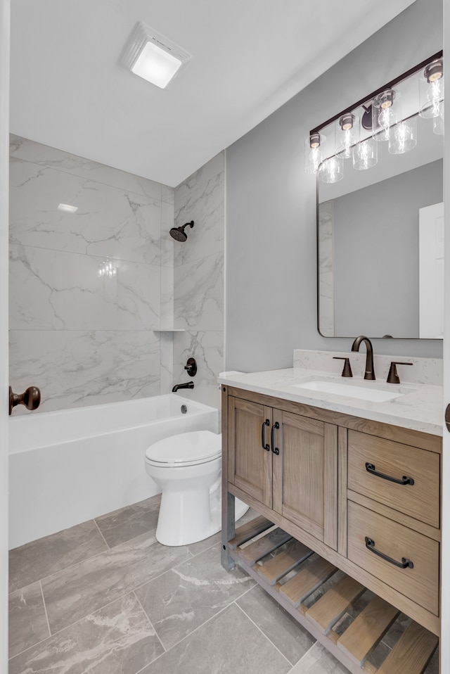 full bathroom featuring tiled shower / bath, vanity, and toilet