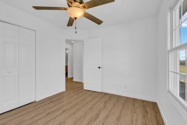 unfurnished bedroom featuring a closet, light hardwood / wood-style floors, and ceiling fan