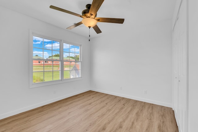 empty room with ceiling fan and light hardwood / wood-style flooring