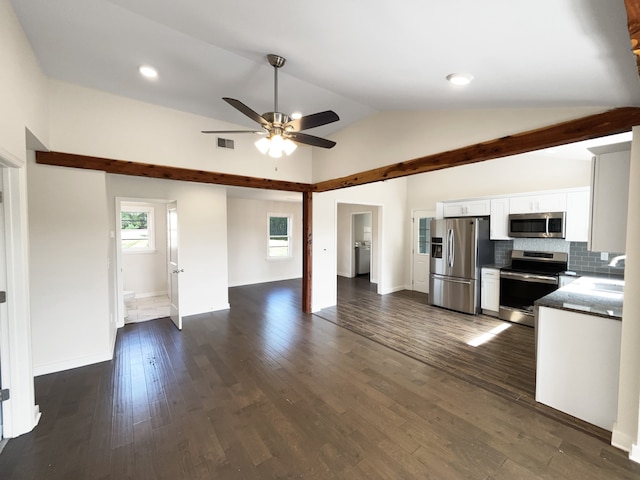 kitchen featuring white cabinets, lofted ceiling, tasteful backsplash, stainless steel appliances, and dark hardwood / wood-style flooring