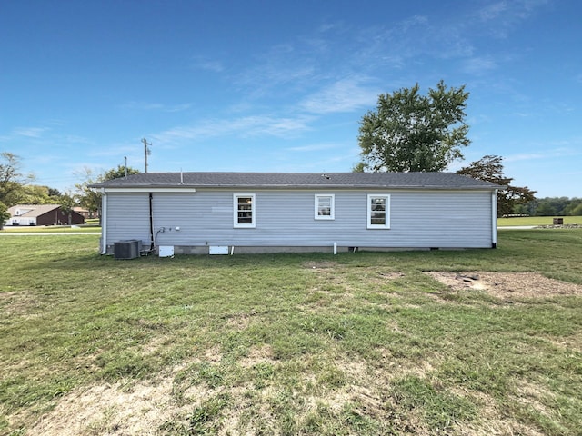 rear view of house featuring a lawn and central AC