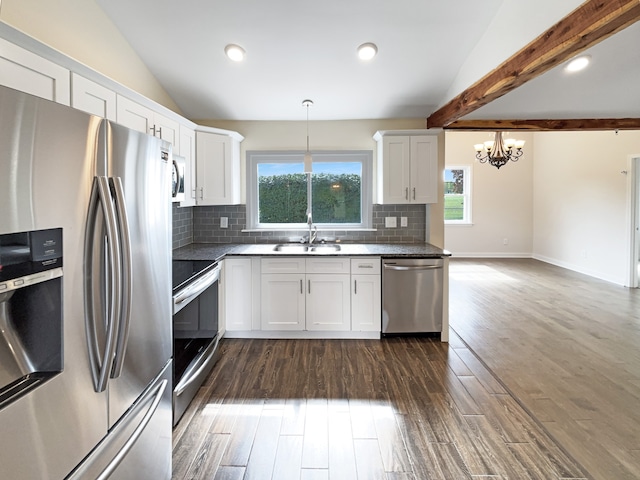 kitchen with appliances with stainless steel finishes, lofted ceiling with beams, sink, and decorative light fixtures