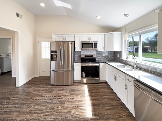 kitchen featuring pendant lighting, dark wood-type flooring, white cabinetry, stainless steel appliances, and separate washer and dryer