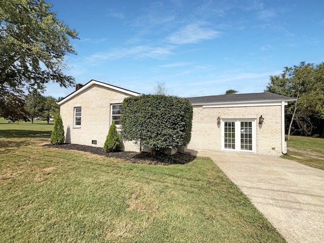 view of front of house featuring a front yard and french doors