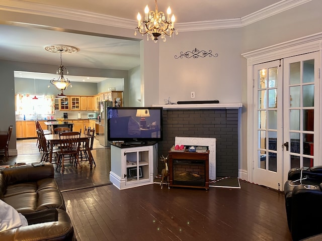 living room featuring wood-type flooring, crown molding, and a brick fireplace