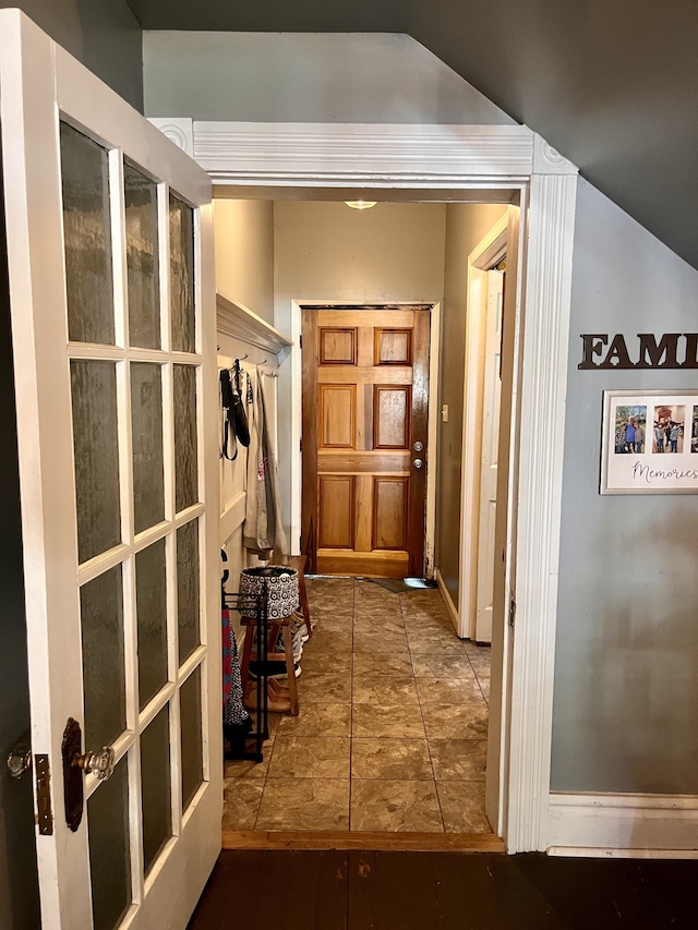 hallway with lofted ceiling and hardwood / wood-style flooring