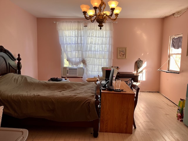 bedroom with cooling unit, a notable chandelier, and light hardwood / wood-style floors