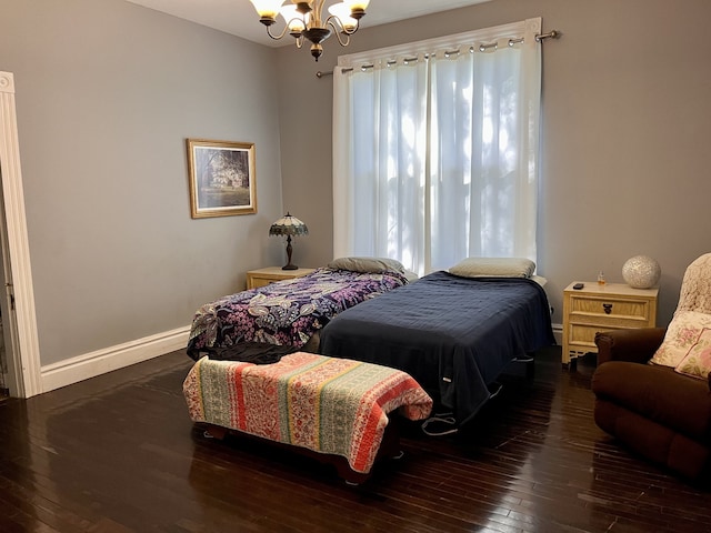 bedroom with dark hardwood / wood-style flooring and a chandelier