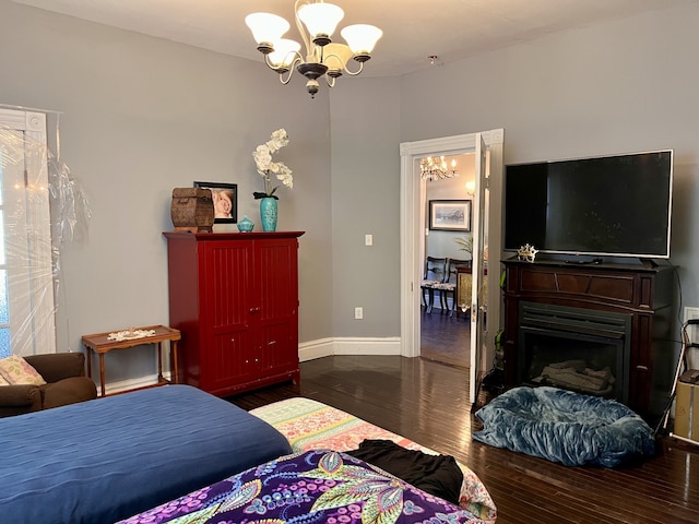 bedroom featuring an inviting chandelier and dark hardwood / wood-style floors