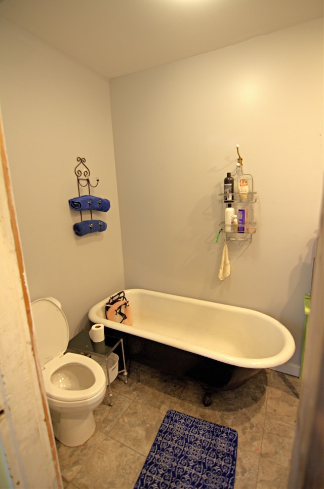 bathroom featuring a tub to relax in and toilet