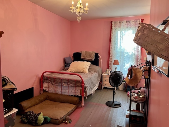 bedroom featuring wood-type flooring and a chandelier