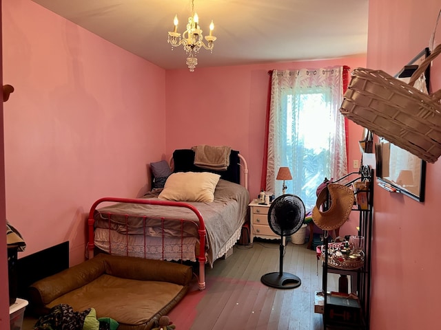 bedroom with hardwood / wood-style floors and a chandelier