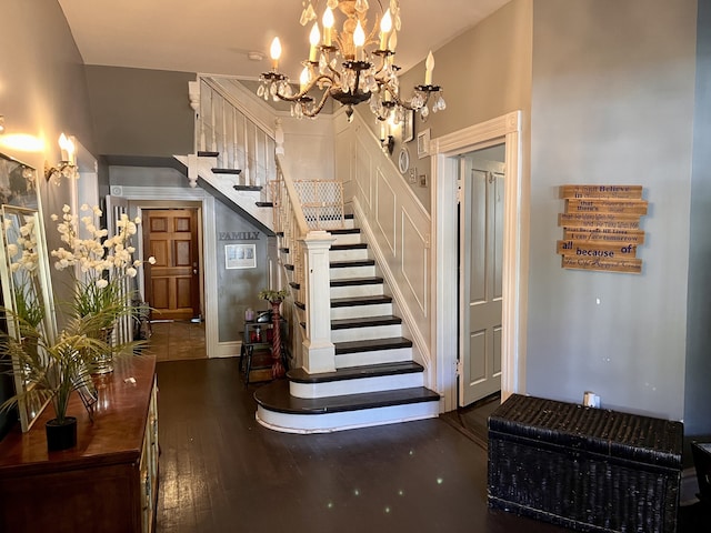 staircase with a notable chandelier and hardwood / wood-style floors