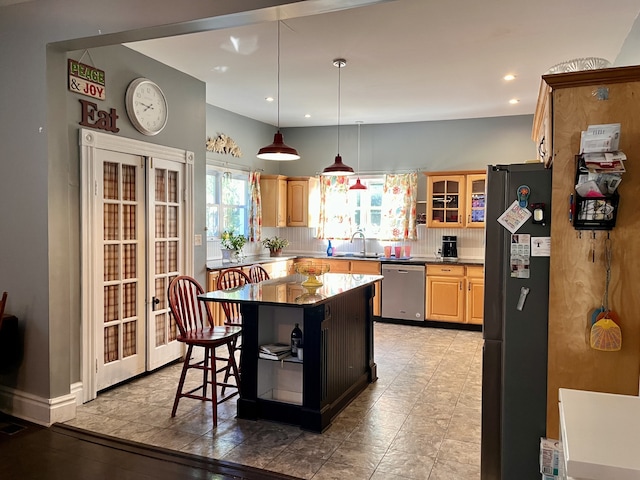 kitchen with sink, a kitchen island, dishwasher, refrigerator, and a breakfast bar area