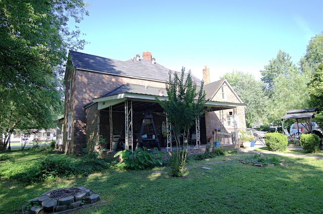 back of property featuring a lawn and a patio