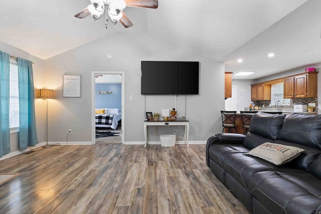 living room featuring wood-type flooring, vaulted ceiling, and ceiling fan