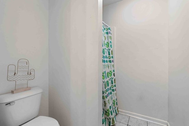 bathroom with a shower with shower curtain, toilet, and tile patterned floors