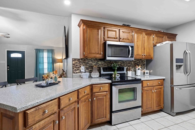 kitchen with backsplash, light tile patterned floors, and stainless steel appliances