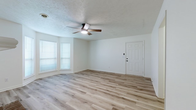 spare room featuring light wood-type flooring, a textured ceiling, and ceiling fan