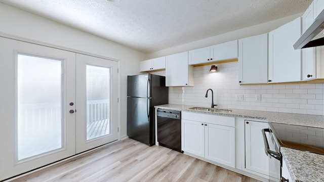 kitchen with light hardwood / wood-style floors, sink, white cabinets, black appliances, and french doors