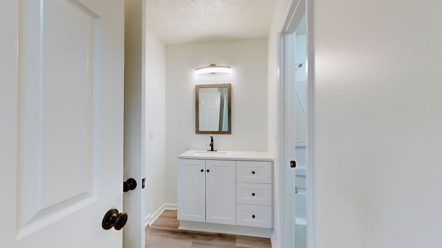 bathroom featuring a textured ceiling, vanity, and hardwood / wood-style flooring