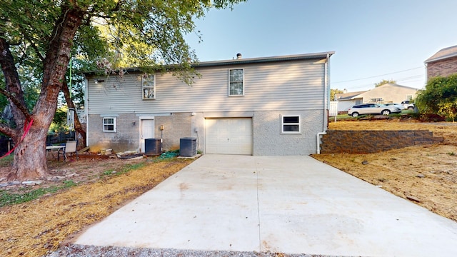 rear view of house with a garage and central air condition unit