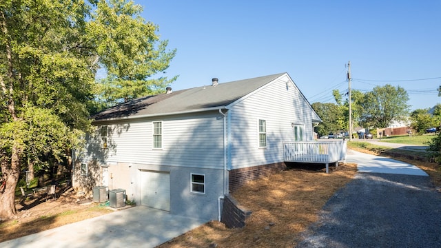 view of property exterior with central AC unit, a garage, and a deck