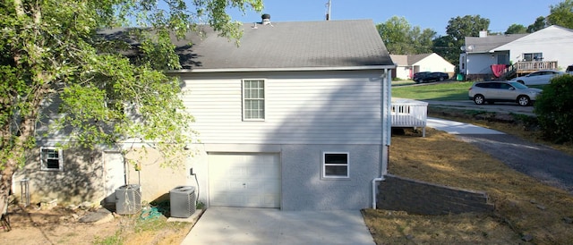 view of home's exterior with a garage and central AC