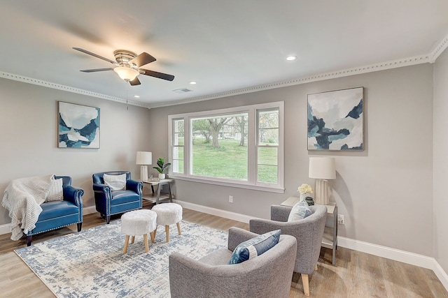 living area with light wood-type flooring, ornamental molding, and ceiling fan