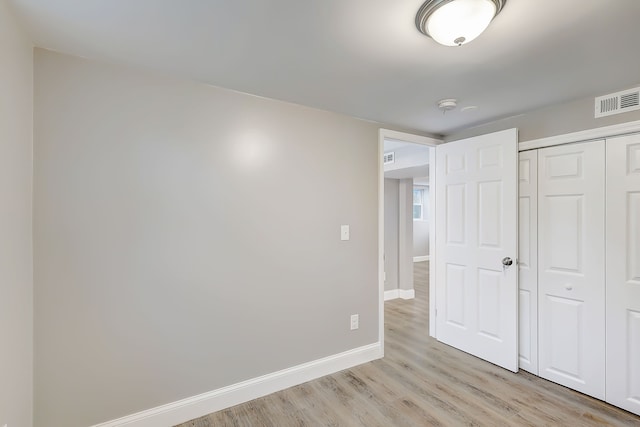 unfurnished bedroom featuring a closet and light hardwood / wood-style floors