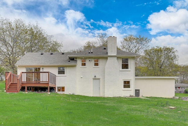 rear view of house featuring a deck and a yard