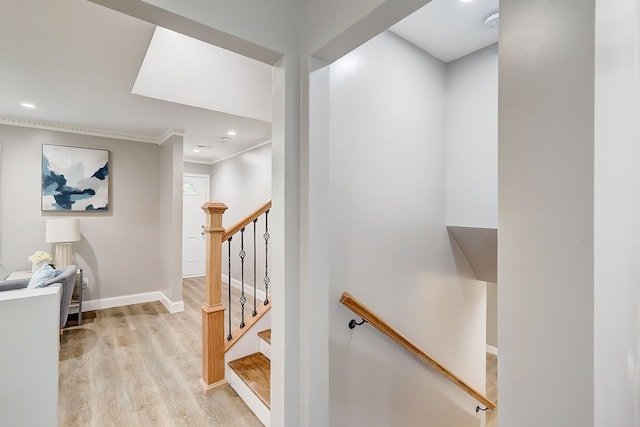 stairway with crown molding and hardwood / wood-style floors