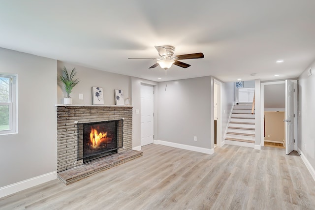 unfurnished living room featuring ceiling fan, light hardwood / wood-style floors, and a fireplace