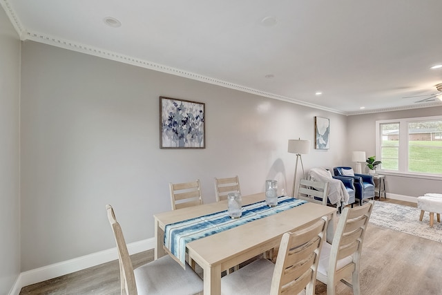 dining area featuring light wood-type flooring, crown molding, and ceiling fan