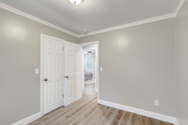 spare room with light hardwood / wood-style floors and crown molding