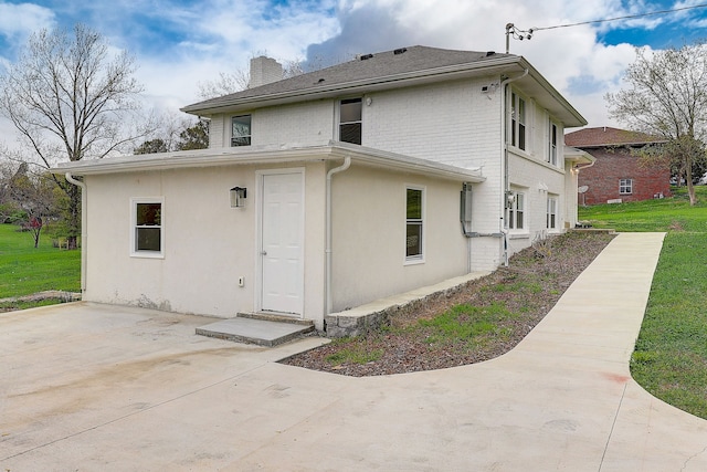 rear view of property featuring a patio area and a yard