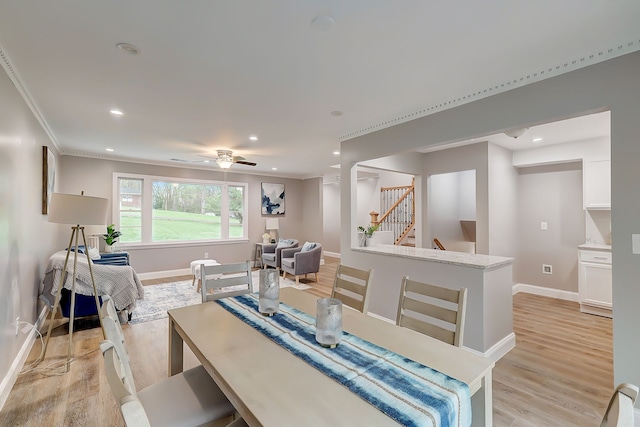 dining area featuring crown molding, light hardwood / wood-style floors, and ceiling fan