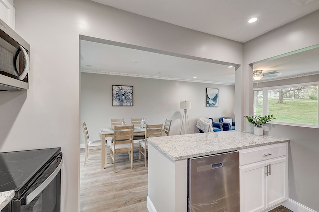 kitchen with ceiling fan, light hardwood / wood-style flooring, white cabinetry, light stone countertops, and crown molding