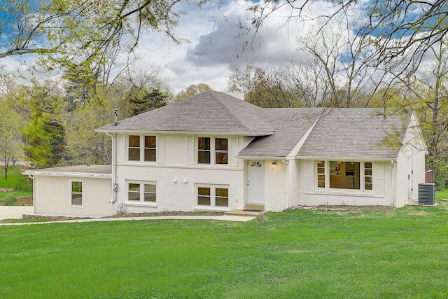 view of front of property with central AC and a front lawn