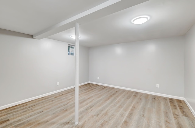 basement with light hardwood / wood-style flooring