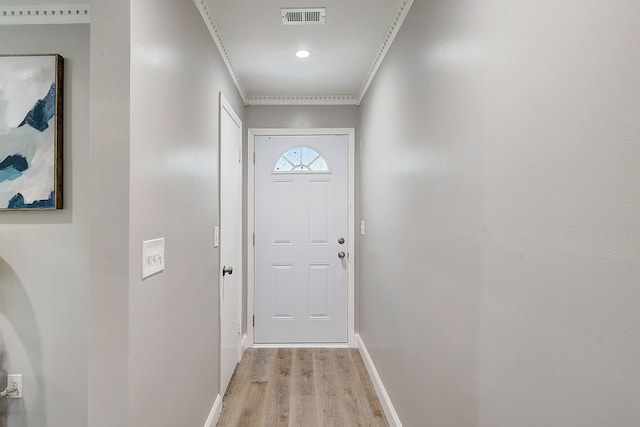 doorway featuring ornamental molding and light hardwood / wood-style floors