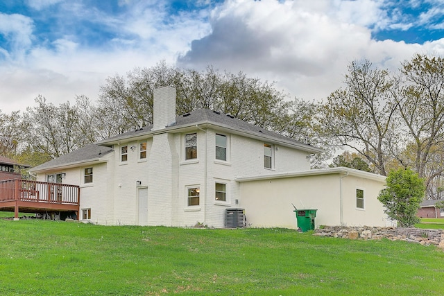 rear view of house featuring central air condition unit, a deck, and a yard